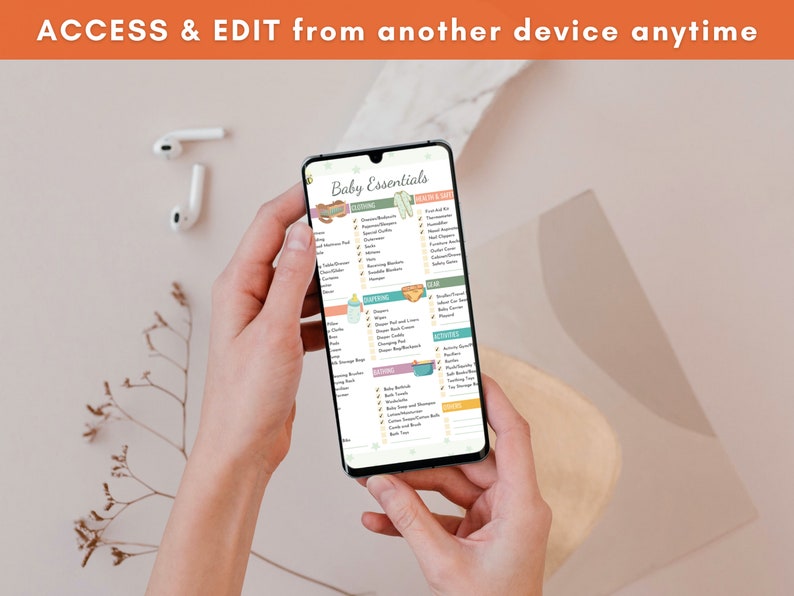 Puede incluir: Un tel&eacute;fono inteligente muestra una lista de verificaci&oacute;n de "Baby Essentials", sostenido por una persona. La pantalla presenta categor&iacute;as como ropa, equipo y actividades, con ilustraciones. El texto en la parte superior dice "ACCESS & EDIT from another device anytime."