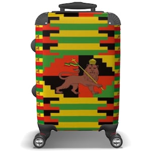 May include: A black suitcase with a colorful design featuring a lion with a crown and a flag. The design is a combination of red, yellow, green, and black stripes.