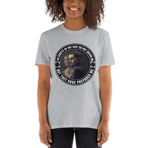 May include: Gray t-shirt with a black and white circular graphic featuring a man's face and the text "The ghosts of my past do not define me but they have prepared me."