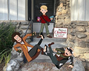 May include: Cartoon yard art featuring characters from a holiday movie. A young boy in a red sweater and green pants holds a toy gun and two other toy devices. Two men are depicted falling down the steps. A sign reads "Merry Christmas ya filthy animal."