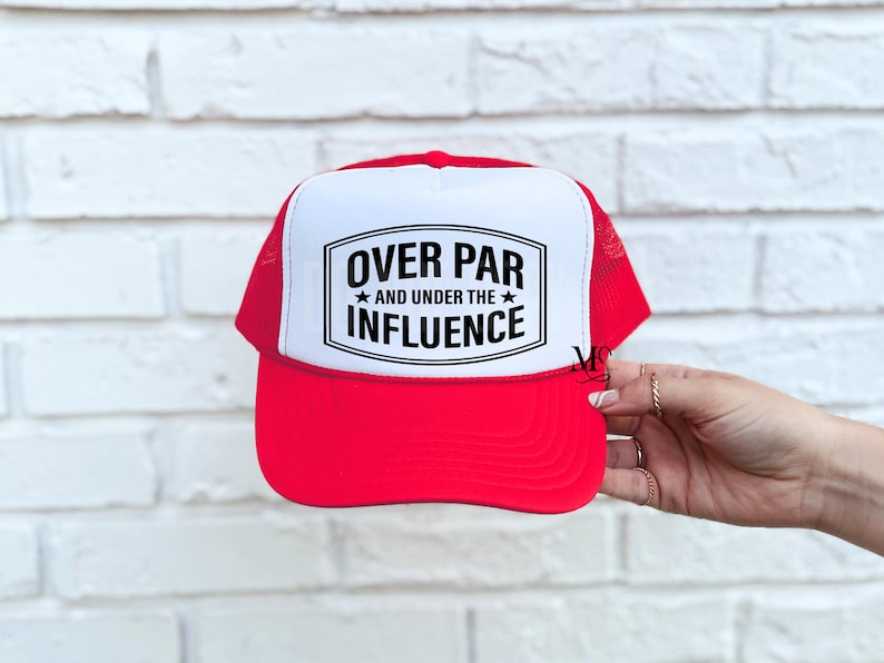 May include: Red and white trucker hat with a black and white graphic that says "Over Par and Under the Influence".