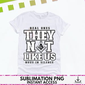May include: White t-shirt with the text "REAL ONES THEY NOT LIKE US MOVE IN SILENCE" in a black, bold font. The design includes a Masonic symbol. The shirt is a classic crew neck style.