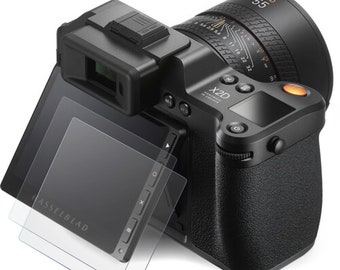 Könnte beinhalten: Eine schwarze Hasselblad X2D Kamera mit einem schwarzen XCD 55mm Objektiv. Die Kamera hat ein schwenkbares Touchscreen-Display auf der Rückseite und einen kleinen orangen Knopf auf der rechten Seite.