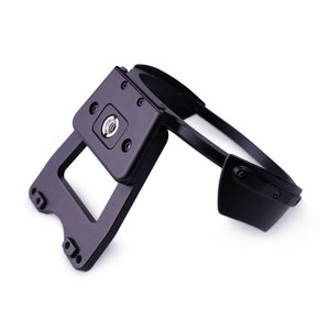 May include: A black metal headband with a mounting plate for a camera or other device. The headband is adjustable and has a secure fit.