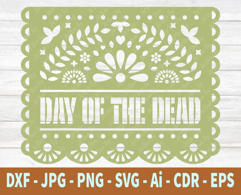 May include: A green Day of the Dead paper banner with a traditional Mexican design. The banner has a scalloped edge and features a floral pattern with the text "Day of the Dead" in white.