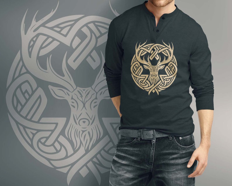 May include: A dark gray long-sleeve shirt with a gold deer head design inside a Celtic knot pattern. The shirt has a button-up collar.