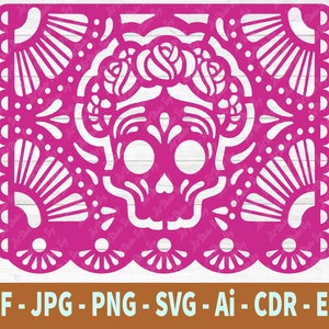 May include: A pink paper cutout of a sugar skull with floral details. The skull is surrounded by a decorative border with a repeating pattern.
