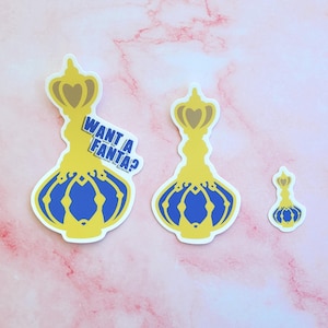 May include: Three yellow and blue glass bottle stickers with a crown on top. The largest sticker has the text "Want a Fanta?" on it.