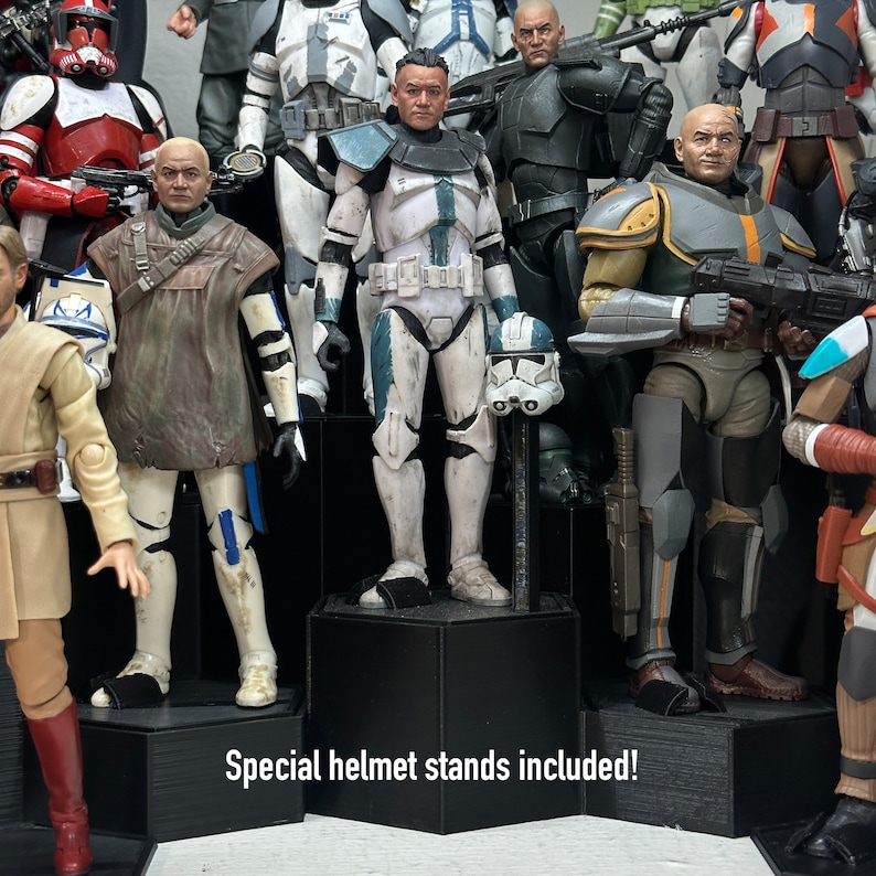 May include: A collection of Star Wars action figures, including a blue and white clone trooper, a brown-clad Jedi, and a black-clad bounty hunter. The figures are displayed on a black hexagonal stand with the text "Special helmet stands included!" printed on the front.