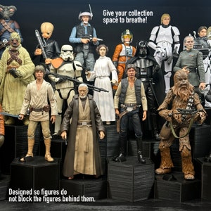 May include: A collection of Star Wars action figures displayed on hexagonal shelves. The figures are arranged in a staggered formation, with the taller figures at the back and the shorter figures at the front. The figures are all wearing their iconic costumes, including Luke Skywalker, Darth Vader, Chewbacca, and Princess Leia. The text "Give your collection space to breathe!" is displayed at the top of the image. The text "Designed so figures do not block the figures behind them." is displayed at the bottom of the image.