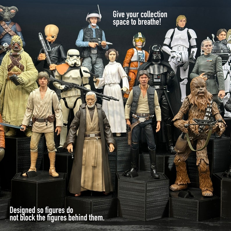 May include: A collection of Star Wars action figures displayed on hexagonal shelves. The figures are arranged in a staggered formation, with the taller figures at the back and the shorter figures at the front. The figures are all wearing their iconic costumes, including Luke Skywalker, Darth Vader, Chewbacca, and Princess Leia. The text "Give your collection space to breathe!" is displayed at the top of the image. The text "Designed so figures do not block the figures behind them." is displayed at the bottom of the image.
