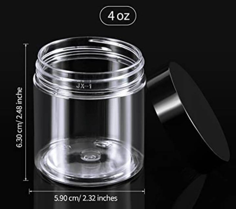 Puede incluir: Tarro de pl&aacute;stico transparente con tapa negra. El tarro mide 5,90 cm de ancho y 6,30 cm de alto, con una capacidad de 4 oz. El tarro tiene forma cil&iacute;ndrica y tapa de rosca. El texto "JX-1" est&aacute; impreso en el tarro.