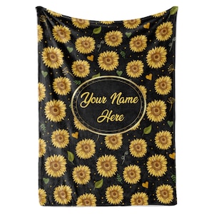 May include: Black fleece blanket with a repeating pattern of yellow sunflowers, green leaves, and gold hearts. The text "Your Name Here" is in a gold oval in the center of the blanket.