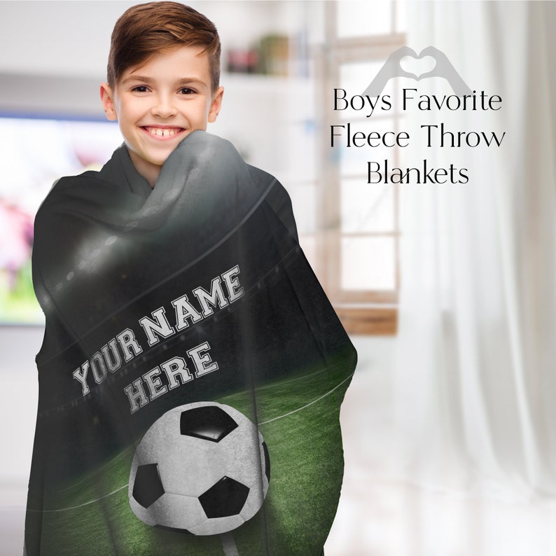 May include: A black fleece throw blanket featuring a football pitch and a football design. The blanket has the text "Your Name Here" printed on it.