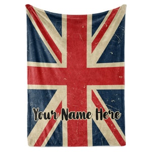 May include: A red, white, and blue Union Jack flag blanket with a distressed vintage look. The text "Your Name Here" is printed in black at the bottom of the blanket.