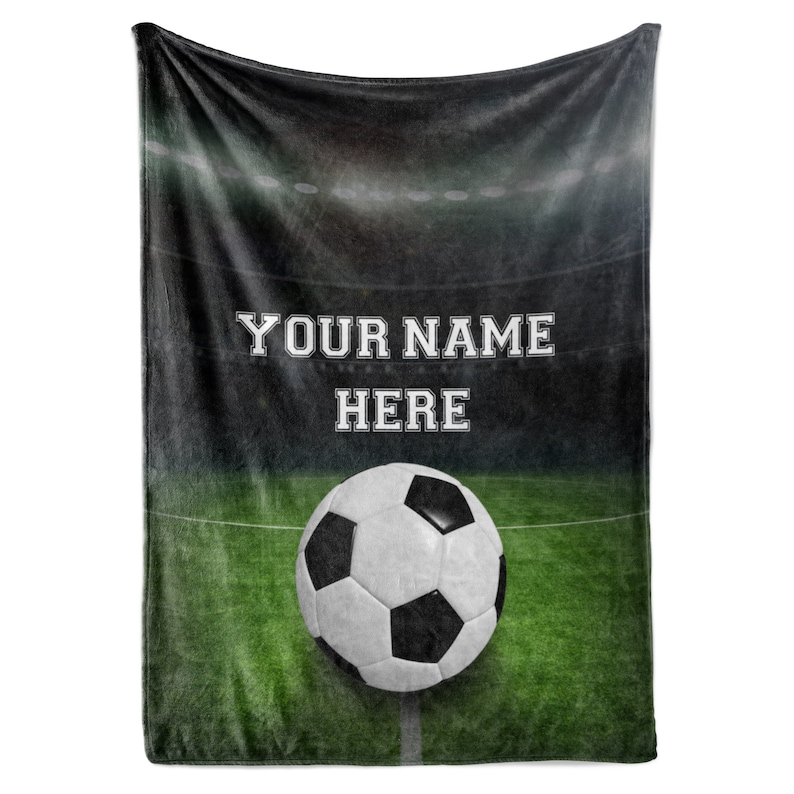 May include: A green and black football pitch with a white football in the centre. The text "YOUR NAME HERE" is printed in white on the pitch.