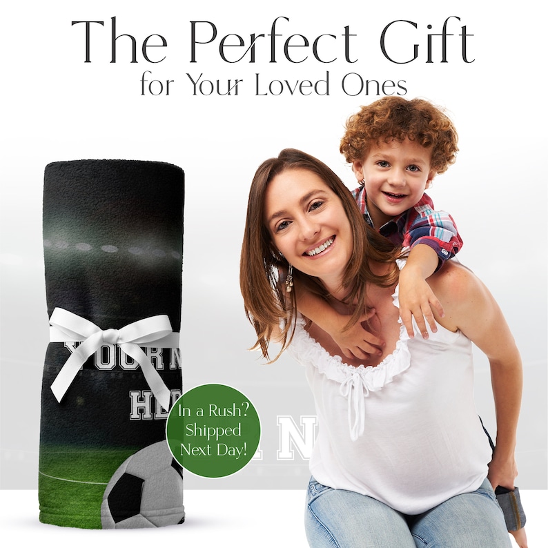 May include: A personalised fleece blanket featuring a football pitch and a football design. The blanket is black and green with white text that says "Your Name Here".
