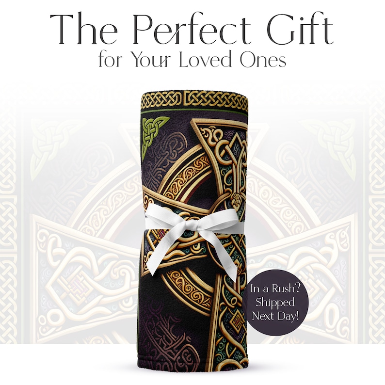 May include: A rolled up fleece blanket with a Celtic knot design in gold and green on a dark purple background. The blanket is tied with a white ribbon.