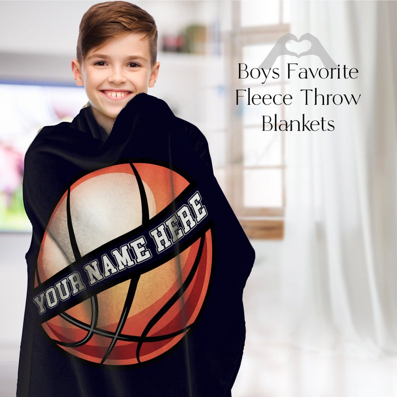 May include: Black fleece throw blanket featuring a basketball design with the text "YOUR NAME HERE" in white. The basketball is orange, brown, and white. The blanket is designed for boys. The text "Boys Favorite Fleece Throw Blankets" is also visible.