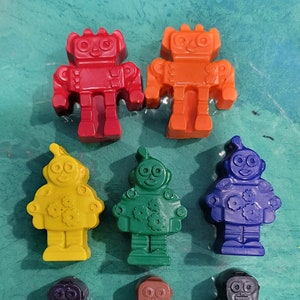 May include: Set of seven robot-shaped crayons in red, orange, yellow, green, blue, purple, and brown.