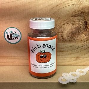 May include: A clear plastic bottle with a white lid and a label that says "life is gourd" with a cartoon pumpkin. The label also says "Pumpkin Spice Scented Bubbles for kids - and kids at heart".