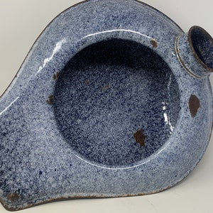 Könnte beinhalten: Ein blaues und weißes, gesprenkeltes Emaille-Bettbecken mit einem Ausguss. Das Bettbecken hat einen abgenutzten, Vintage-Look.