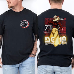 May include: Black t-shirt featuring the "Demon Slayer" logo on the front. The back of the shirt displays a graphic of a character with Japanese text and the words "Infinity Castle". The design includes red, yellow, and white accents.