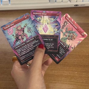 May include: Three Magic: The Gathering trading cards featuring goblin illustrations in shades of pink and red. The cards are titled Pashalik Mons, Brightstone Ritual, and Zada, Hedron Grinder, each displaying detailed character artwork and game text.
