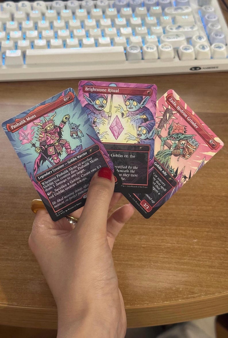 May include: Three Magic: The Gathering trading cards featuring goblin illustrations in shades of pink and red. The cards are titled Pashalik Mons, Brightstone Ritual, and Zada, Hedron Grinder, each displaying detailed character artwork and game text.