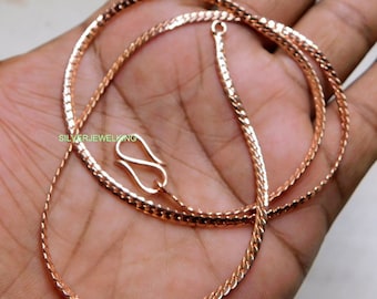 May include: A rose gold chain necklace with a lobster clasp closure. The chain is made of a delicate, braided design.