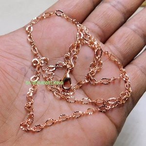 May include: A rose gold chain necklace with a delicate, textured design. The chain is approximately 18 inches long and has a lobster claw clasp.