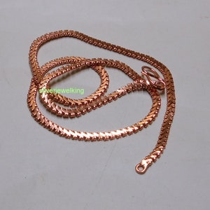 May include: A rose gold chain necklace with a delicate, herringbone pattern. The chain is made of metal and has a lobster clasp closure.