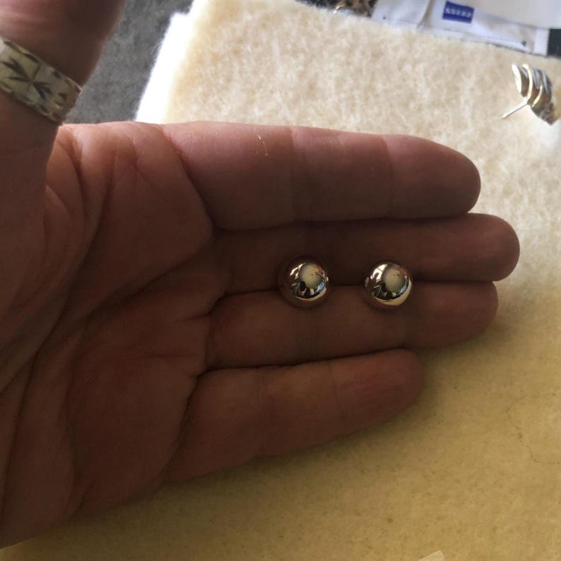 Op de afbeelding: Een paar zilveren oorbelletjes met bolletjes.