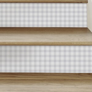 Pode incluir: Escadas de madeira com um padrão xadrez cinza e branco nos degraus.