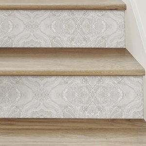May include: Close-up of wooden stairs with a white and gray patterned wallpaper on the risers. The wallpaper has a subtle marbleized effect.