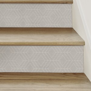 May include: Close-up of wooden stairs with a geometric pattern wallpaper on the risers. The wallpaper is a light gray with a white geometric pattern.