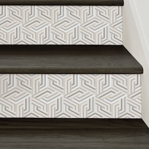 May include: Close-up of a set of dark wood stairs with a geometric pattern of white, gray, and beige lines on the risers.