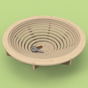 May include: A wooden bowl with a unique design, featuring concentric circles that create a layered effect. The bowl is made of light brown wood and has a natural finish. A silver key is placed in the center of the bowl.