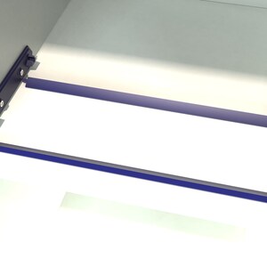 May include: Close-up of a white cabinet with two blue metal shelf supports. The supports are attached to the cabinet with screws.
