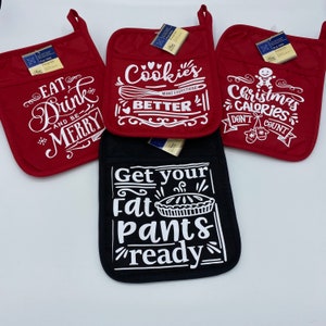 Pode incluir: Quatro pegadores de panela vermelhos e pretos com texto branco. Os pegadores vermelhos têm o seguinte texto: "Eat Drink and Be Merry", "Cookies Make Everything Better" e "Christmas Calories Don't Count". O pegador preto tem o texto "Get Your Fat Pants Ready".