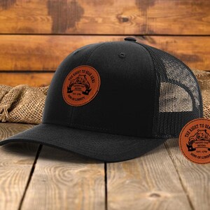 May include: Black trucker hat with a brown leather patch that says "The Right to Bear Arms" with a bear and the words "Defend the Second" and "Sons of Liberty".