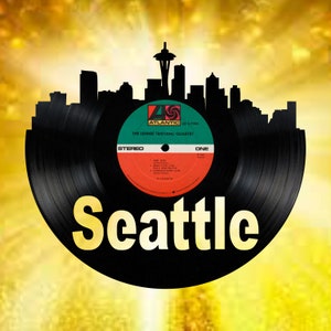 May include: A black vinyl record with a silhouette of the Seattle skyline, including the Space Needle, and the text "Seattle". The record label is green, red, and white with the text "The Lennie Tristano Quartet" and "Atlantic" in a circular logo.