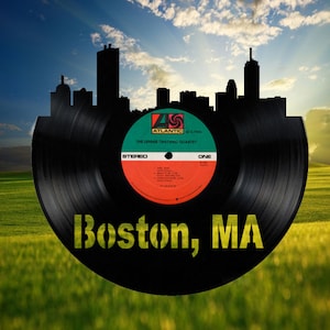 May include: A black vinyl record with a cityscape silhouette, the text "Boston, MA" and the album title "The Lennie Tristano Quartet" on a green grassy field.