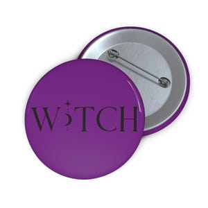 May include: A round purple pin-back button featuring the black text WITCH, where the letter I is replaced by a vertical star and crescent moon symbol. The back of the button is metallic silver with a horizontal pin mechanism for attachment.