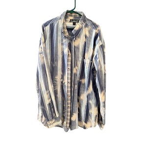 May include: A long-sleeved button-down shirt with vertical stripes in shades of blue and white, with a bleached effect. The shirt has a plaid pattern on the inside collar and placket, and a pocket on the left chest. The brand name "Lookin" is visible on the collar.