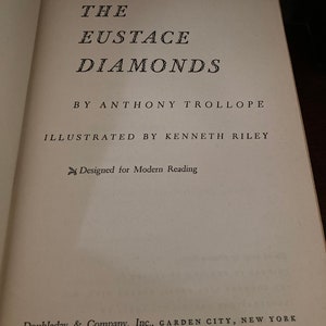 May include: Open book page with the title "THE EUSTACE DIAMONDS" by Anthony Trollope, illustrated by Kenneth Riley. The text is in black font on a cream-colored page. The publisher is Doubleday & Company, Inc., Garden City, New York.