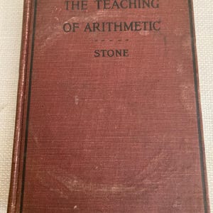 Może przedstawiać: Zabytkowa książka zatytułowana "THE TEACHING OF ARITHMETIC STONE" z teksturowaną, czerwonobrązową okładką. Tytuł jest w białych, wielkich literach. Książka ma czarną obwódkę i nosi ślady użytkowania.