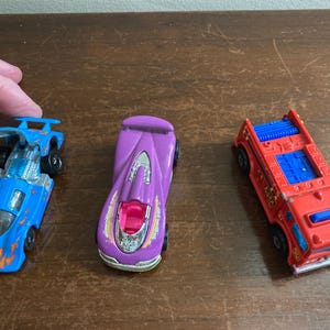 Drei Vintage Hot Wheels Autos.