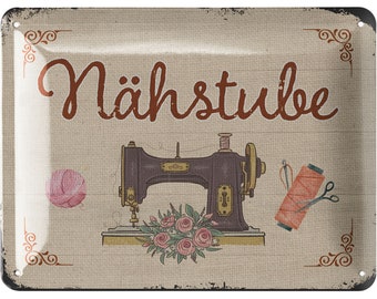 May include: A vintage-style metal sign with the word "Nähstube" in brown script. The sign features a sewing machine, a ball of pink yarn, a spool of thread, and a bouquet of pink roses. Decorative corner accents.