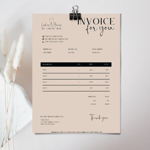 May include: A beige invoice titled "Invoice for you" with the business name "Lashes & Brows by Chloe Mae" at the top. The invoice is held by a black clip and includes sections for item descriptions and totals. Decorative dried flowers are in the background.